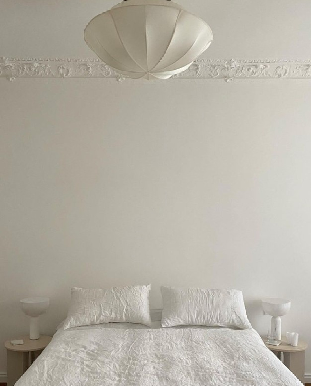 Serene warm greige white bedroom with ornamental crown molding and low side tables - @rebeccagoddard.