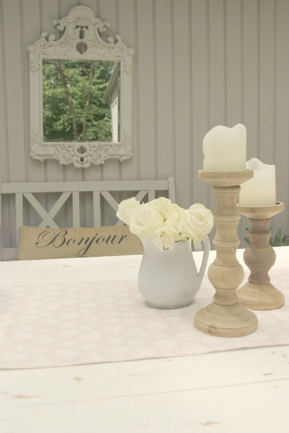 Rustic candle holders, white roses, and a French mirror in our courtyard - Hello Lovely Studio.
