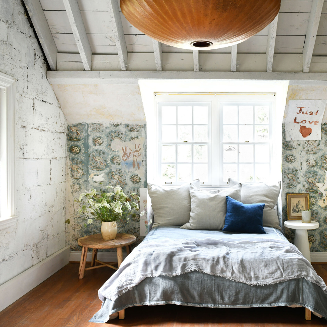 Rustic modern bedroom by Leanne Ford with partially removed wallpaper and rough textured walls - photo by Erin Kelly.