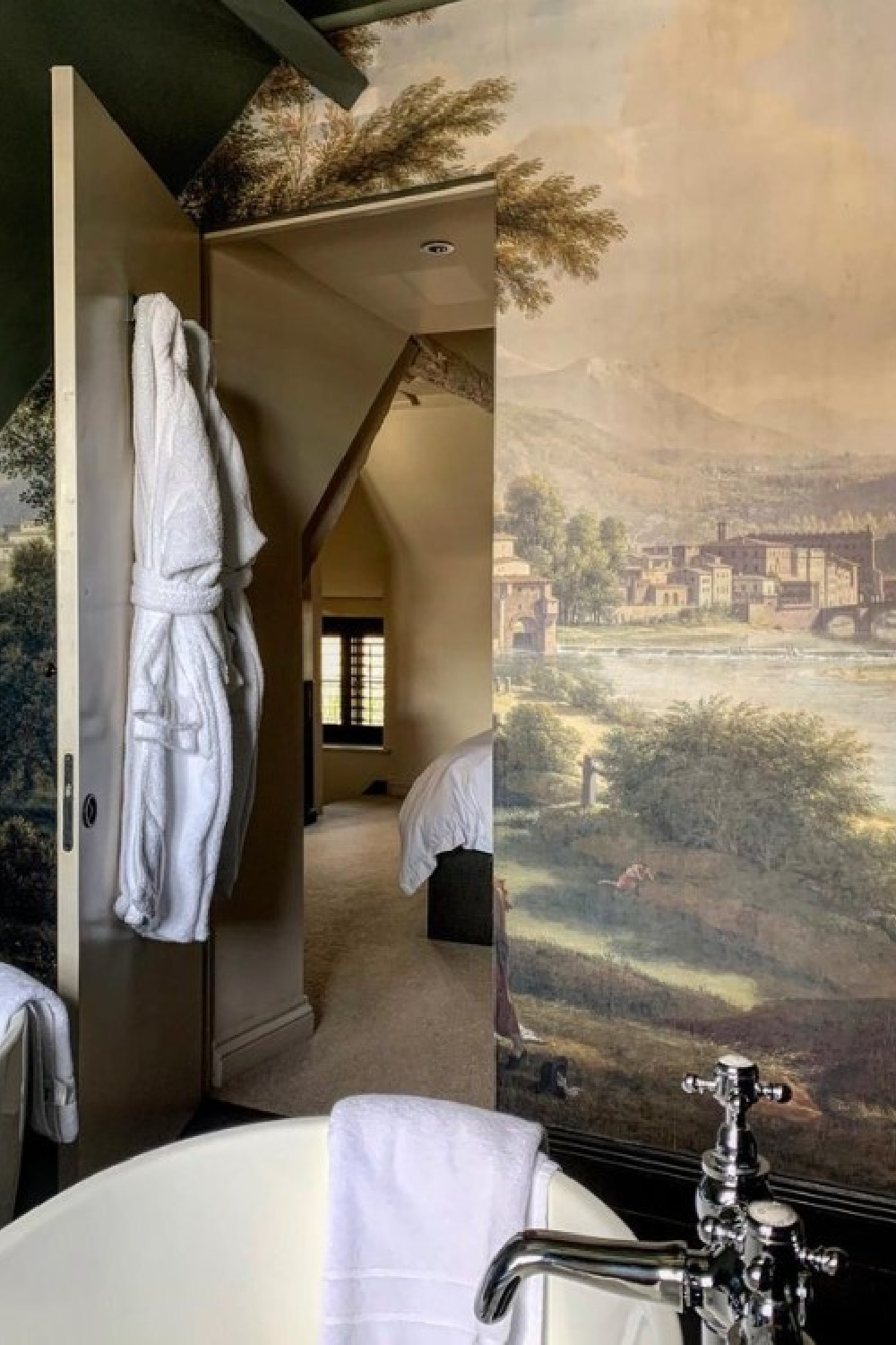 Jib door with scenic mural in a luxurious English country cottage bath - Peony Cottage - a vacation rental in the Cotswolds - @peonycottagecotswolds. #cotswoldscottage #englishcountry