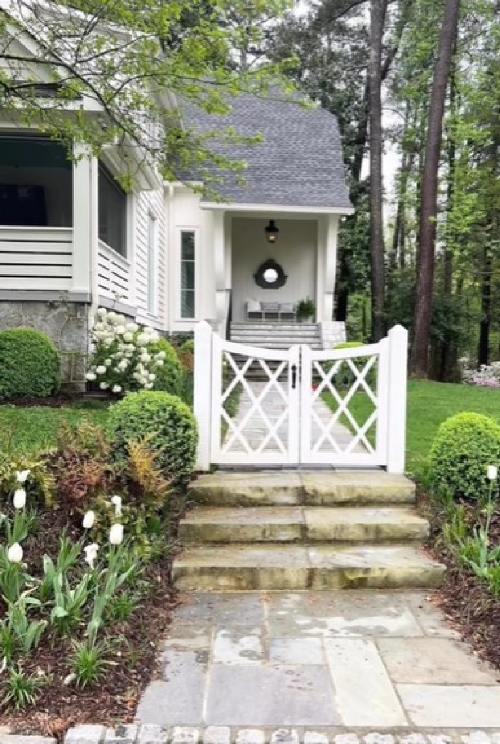 Beautiful curb appeal with charming gate, stone, and tulips - photo by Sherry Hart.