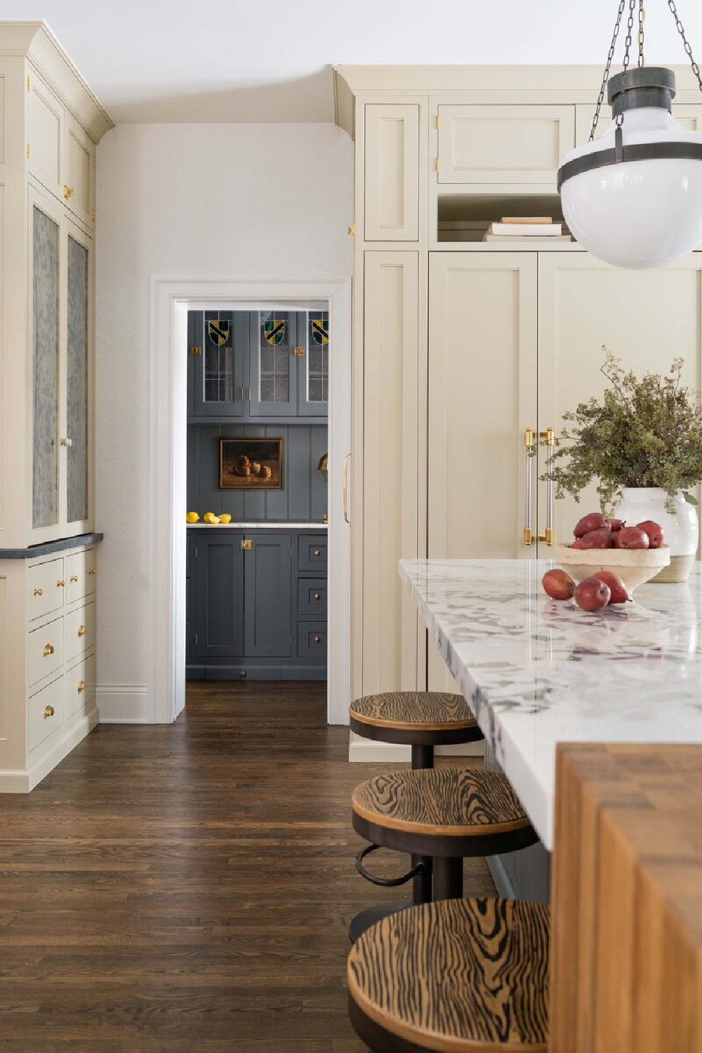 Warm white kitchen with dark painted island (design by Whittney Parkinson). #warmwhitekitchencabinets #whitekitchencabinets