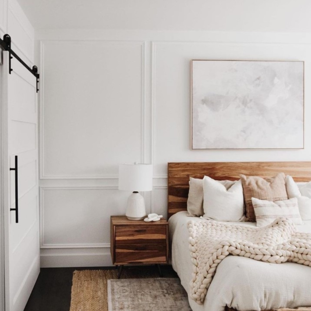 Bedroom with applied trim on walls painted Chantilly Lace with rustic wood headboard and coordinating nightstand - @amypeters.