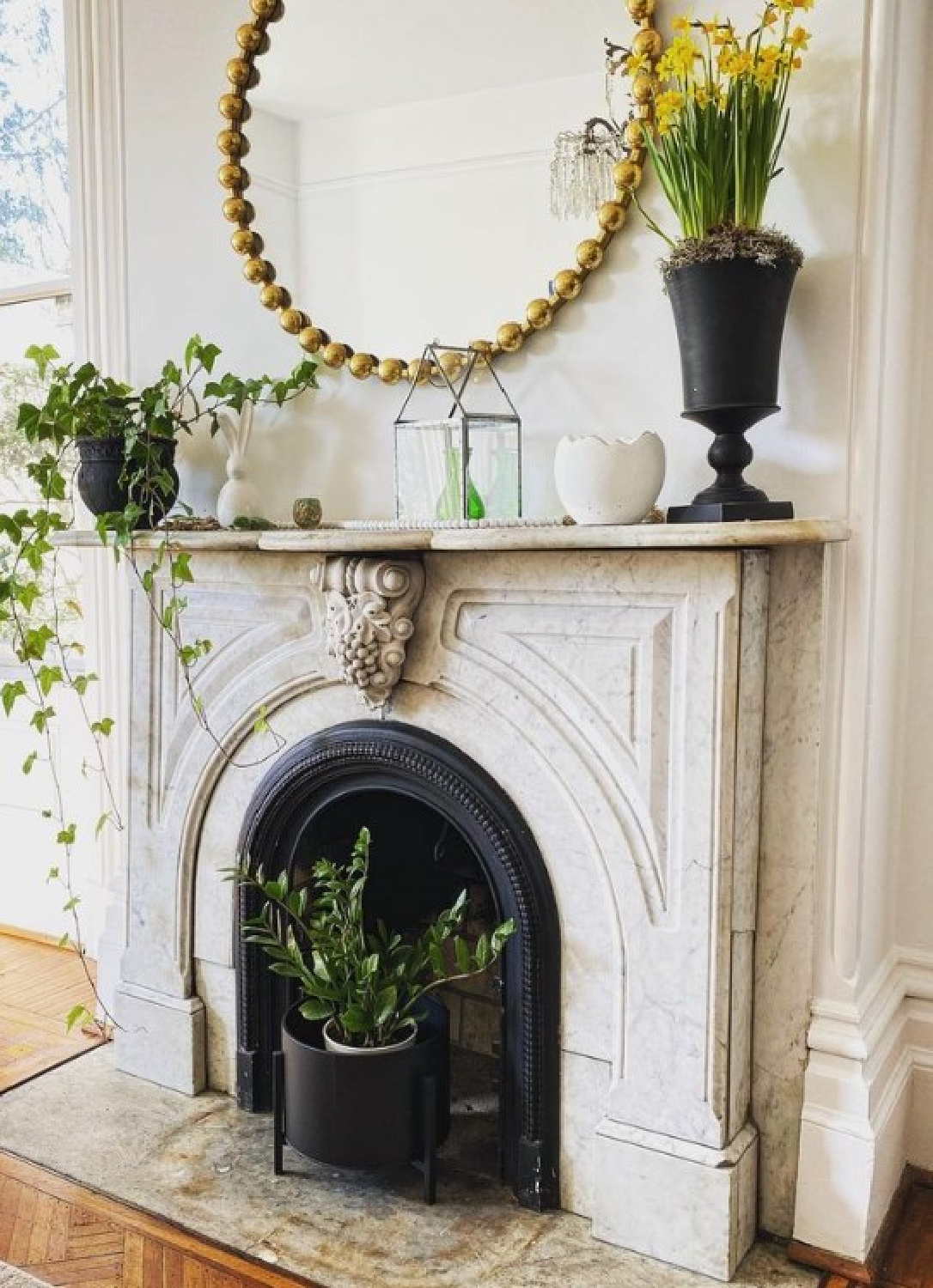 Beautiful 1920s marble fireplace styled with a round mirror and Chantilly Lace white on walls - @sandycuccidesign. #chantillylace