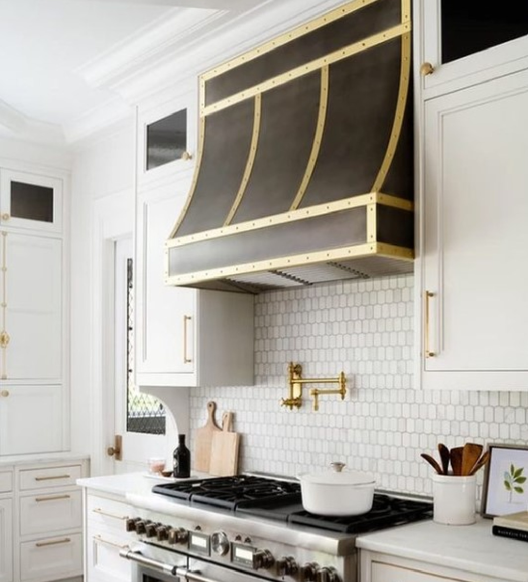 White kitchen cabinets painted Chantilly Lace (Benjamin Moore) and paired with elegant dark range hood with brass - @brittdesignstudio. #chantillylace