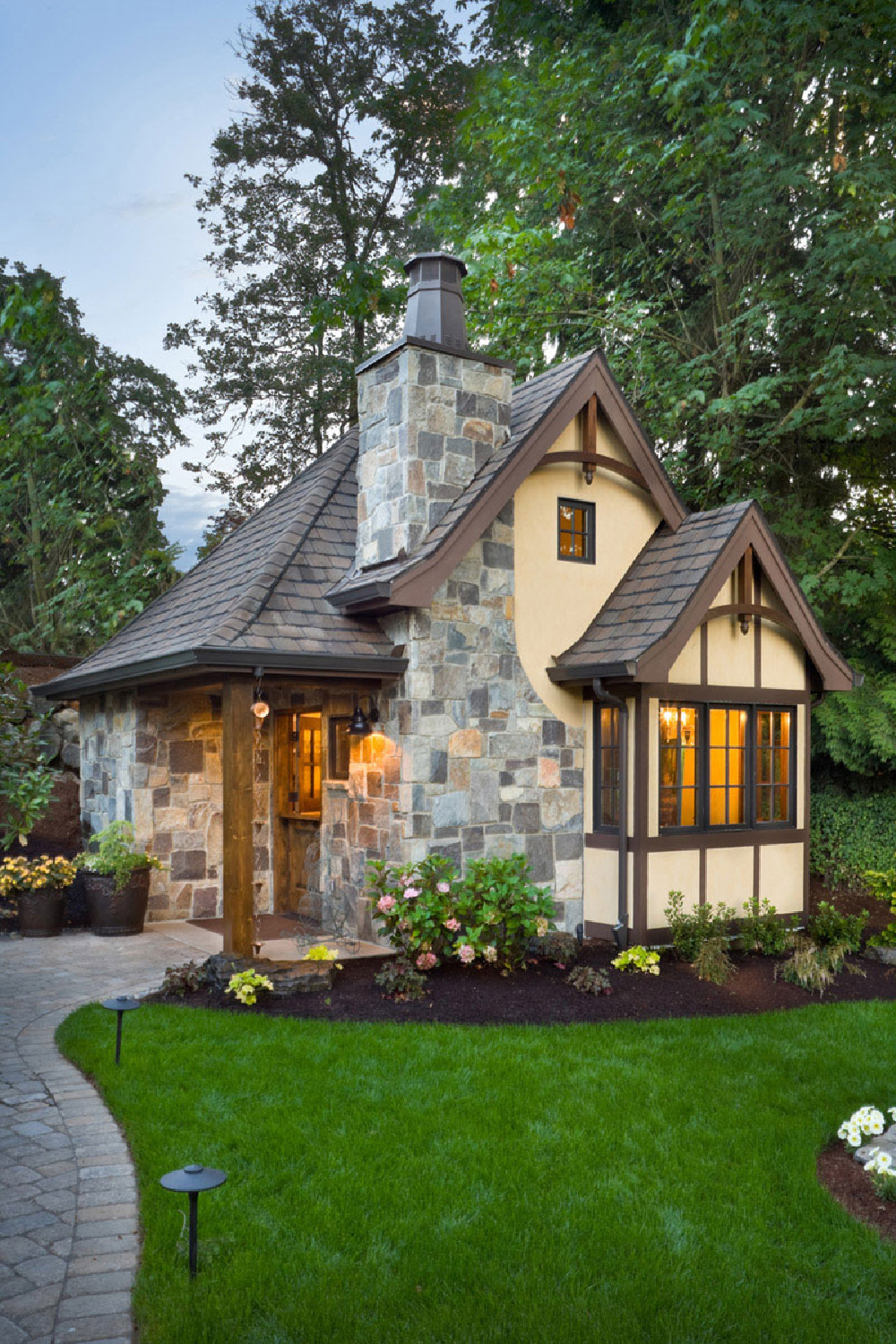 300 square foot tiny house cottage (Clarendon model) with Dutch door, vaulted ceiling, stone chimney and Tudor style details - @thehousedesigners. #tinyhousedesign #tinycottages