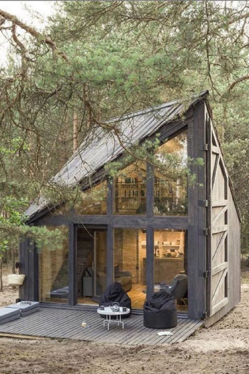 Modern rustic tiny house with two floors of woodsy warmth, walls of windows, and exquisite architecture - @settdesign. #tinyhousearchitecture #tinyhouseexteriors #modernrusticcabin