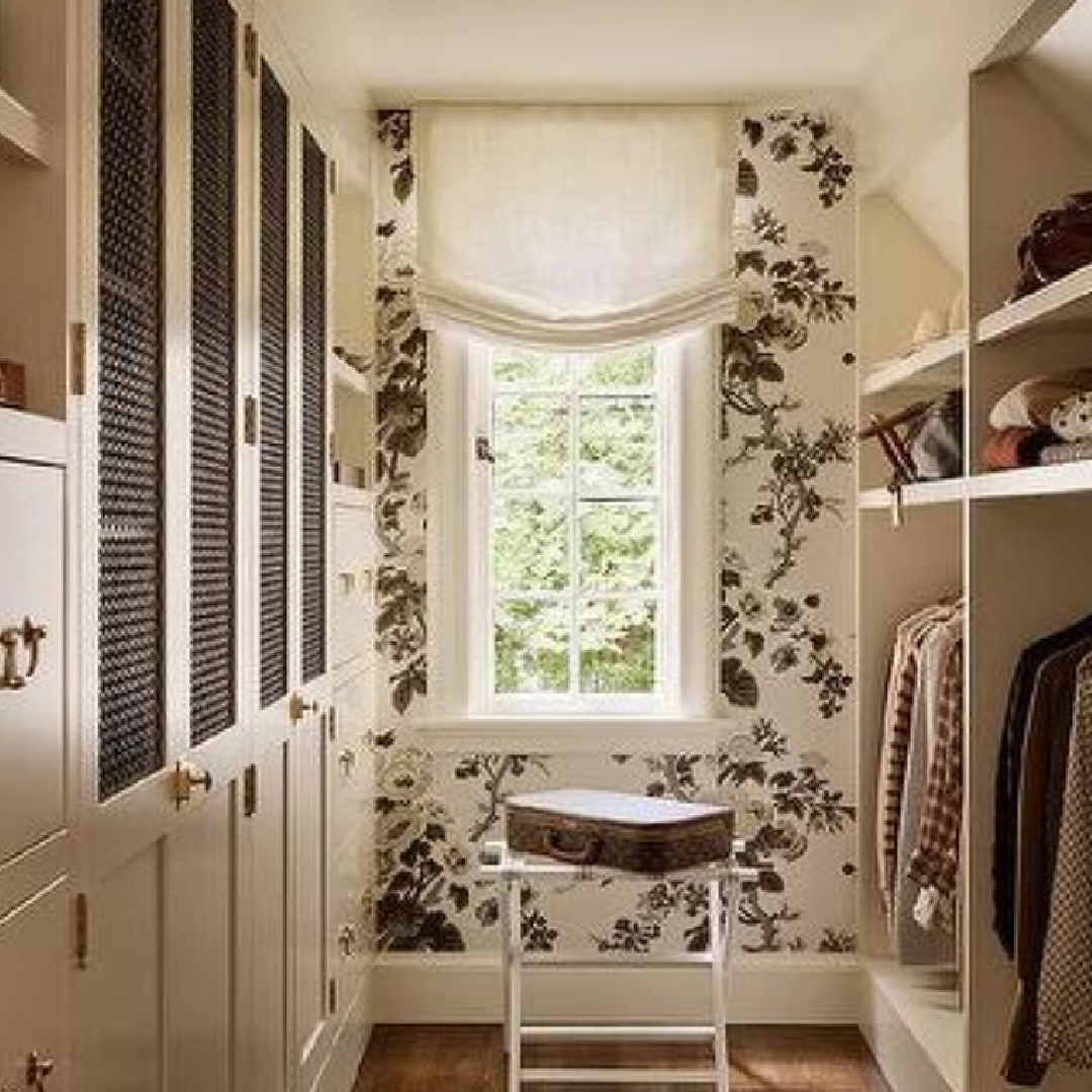 Beautiful custom closet (Katie Rosenfeld Design) with window, Pyne Hollyhock Schumacher wallpaper, built-ins, and Roman shade. #customclosets #bespokecloset #pynehollyhock