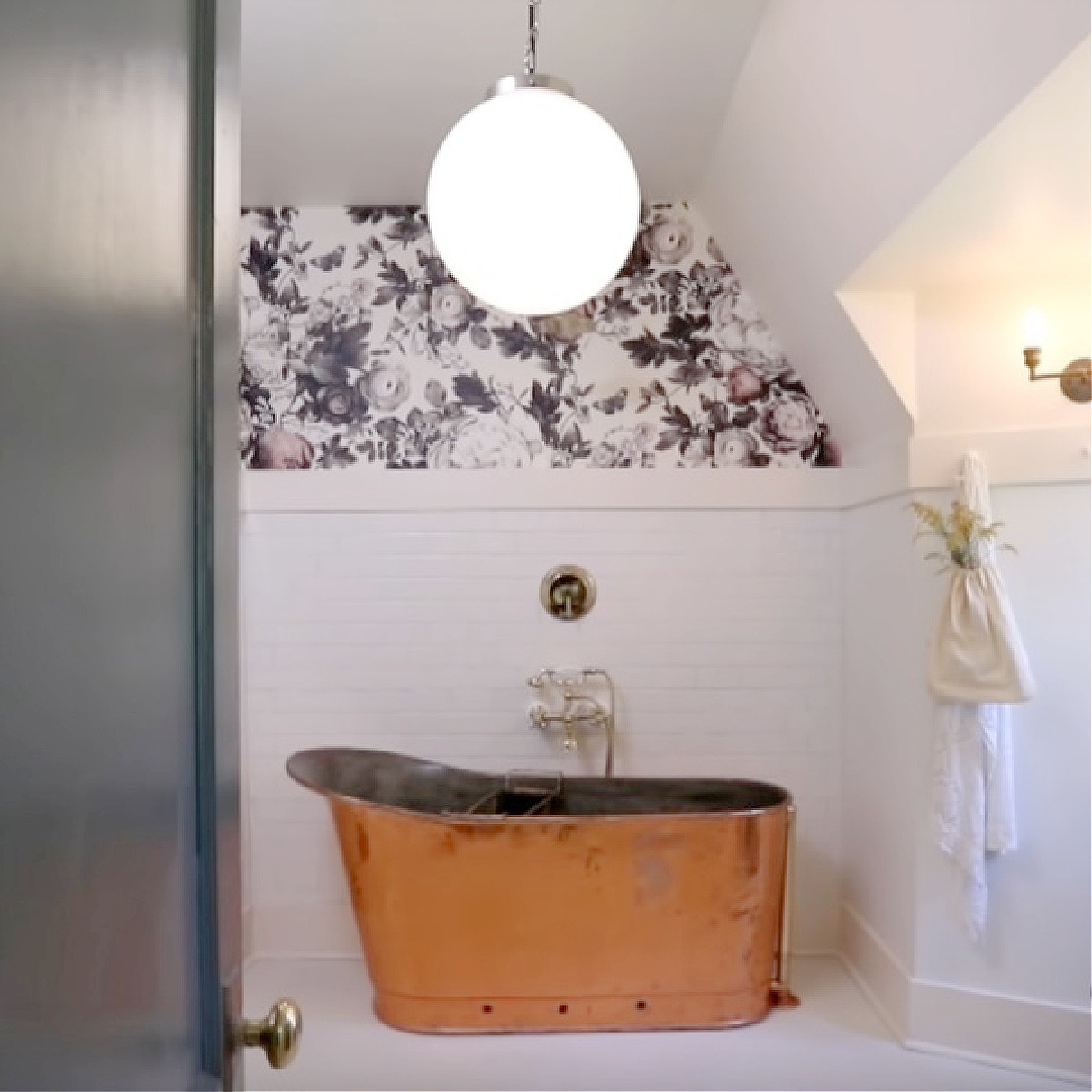 Leanne Ford designed bathroom with copper tub, Ellie Cashman Summer Squall wallpaper, globe pendant, and PPG Delicate White paint color. This is from the Smith project on Restored by the Fords.