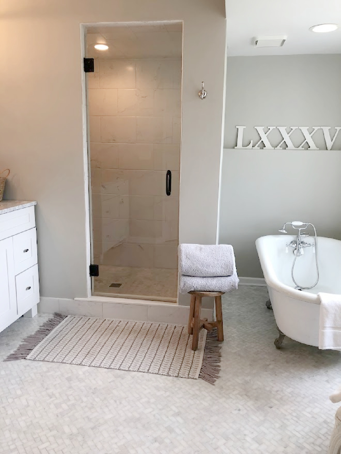 SW Repose Gray walls, white Grecian herringbone marble mosaic tile floor, vintage clawfoot tub, and spa like walk in shower in our modern French renovated bath at the Georgian - Hello Lovely Studio.