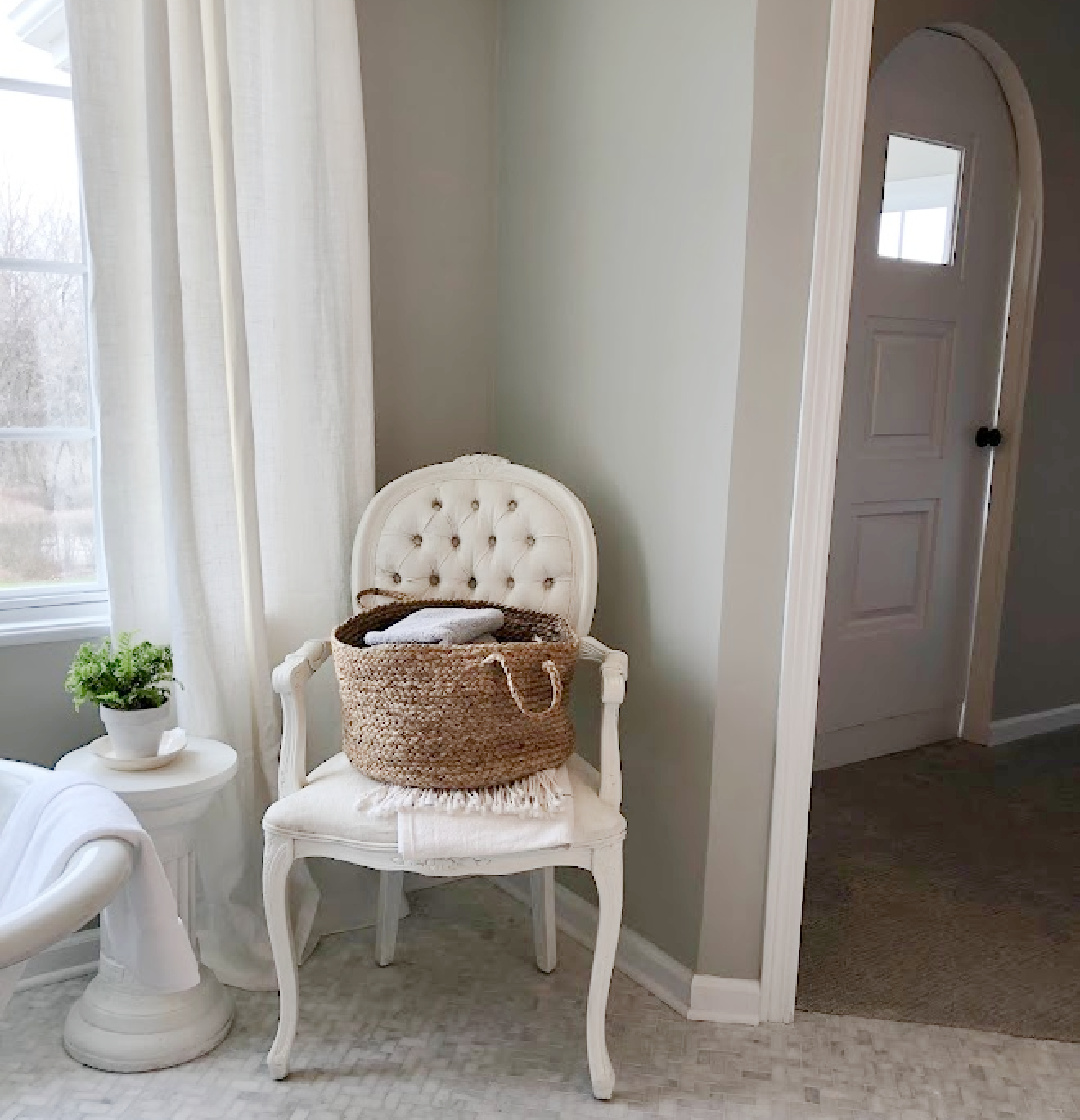 SW Repose Gray walls, Louis style tufted armchair, linen curtains, and herringbone marble mosaic tile floor in our modern French renovated bath at the Georgian - Hello Lovely Studio.