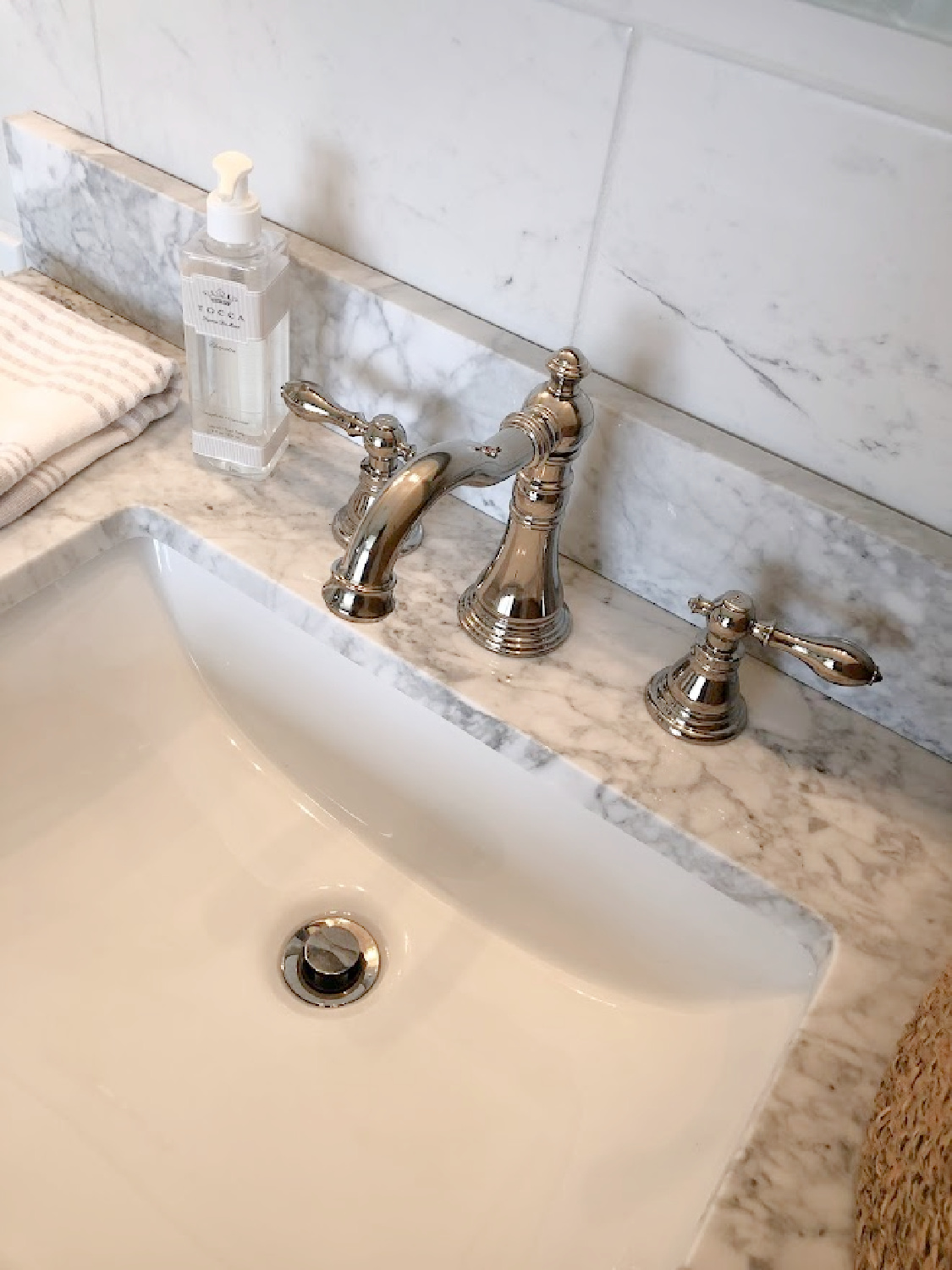 Detail of Edwardian style polished nickel bath faucet and carrera marble vanity top in our renovated bath at the Georgian - Hello Lovely Studio.