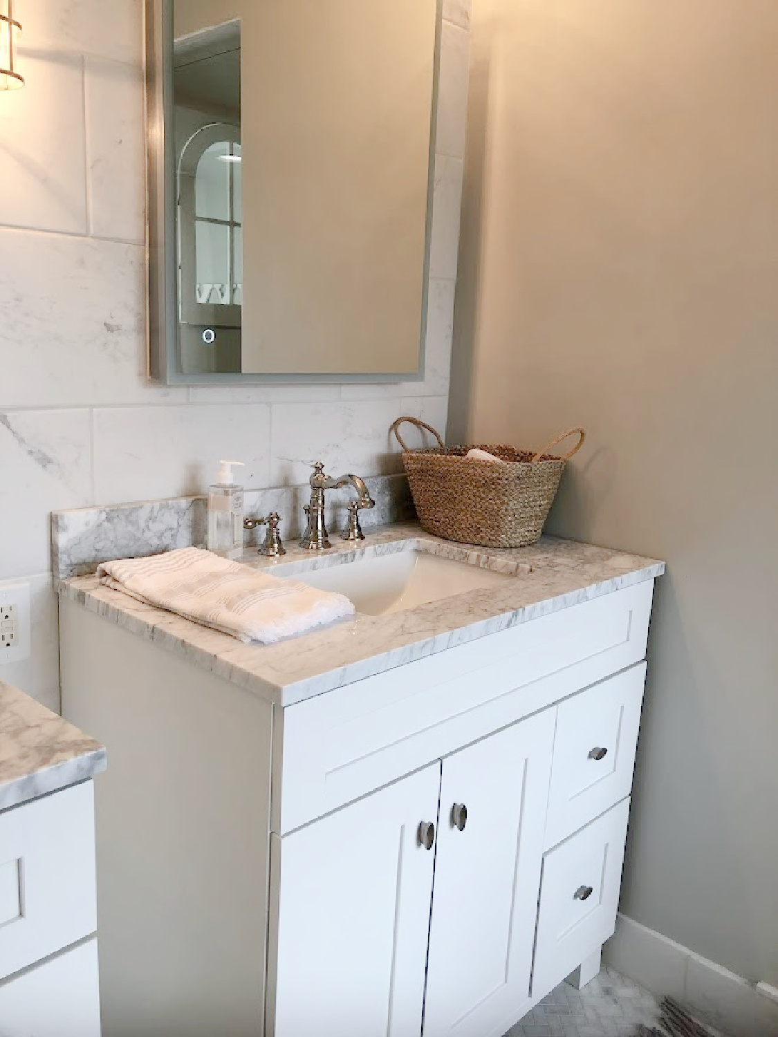 White Shaker style bath vanity with Edwardian style polished nickel faucet and modern mirrored medicine cabinet in our modern French renovated bath - Hello Lovely Studio.