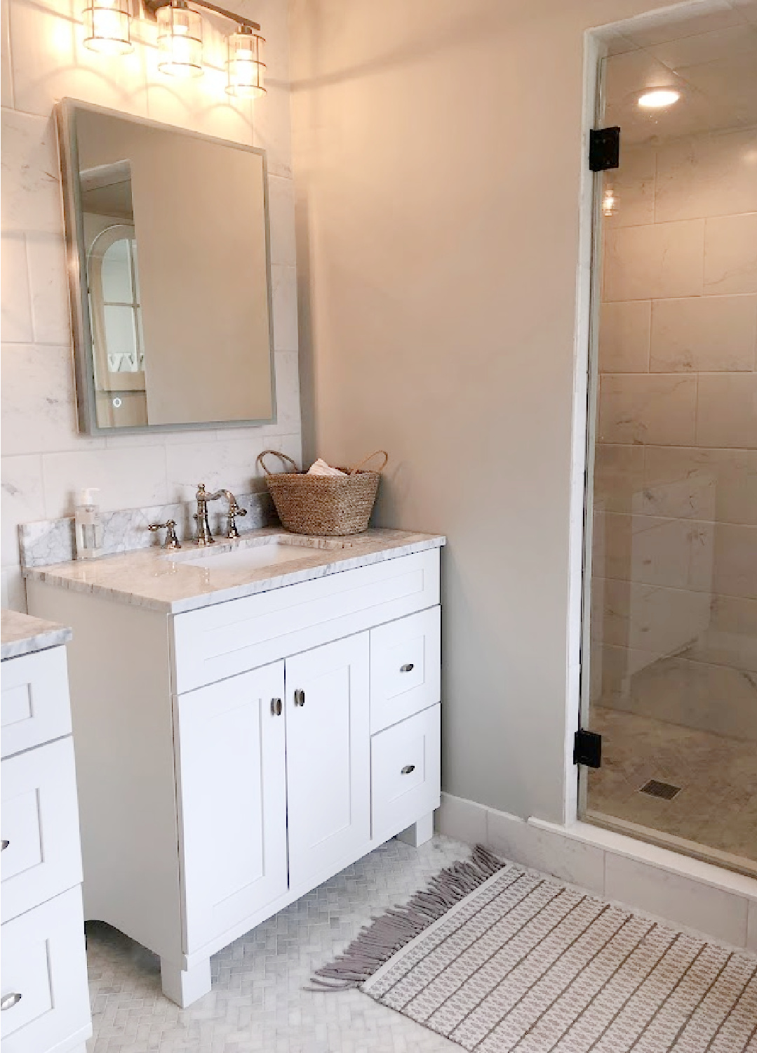 White Shaker style bath vanity with Edwardian style polished nickel faucet and modern mirrored medicine cabinet in our modern French renovated bath - Hello Lovely Studio.