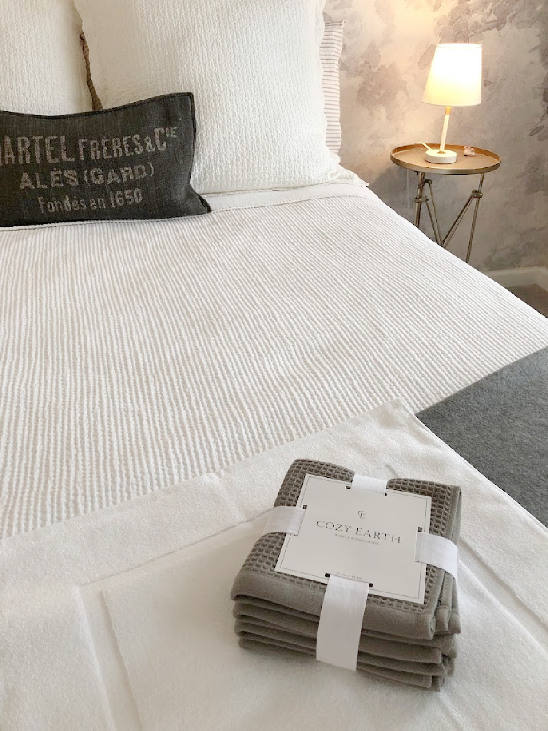 Cozy Earth dark gray waffle weave washcloths and white bath mat in a modern French bedroom suite - Hello Lovely Studio.