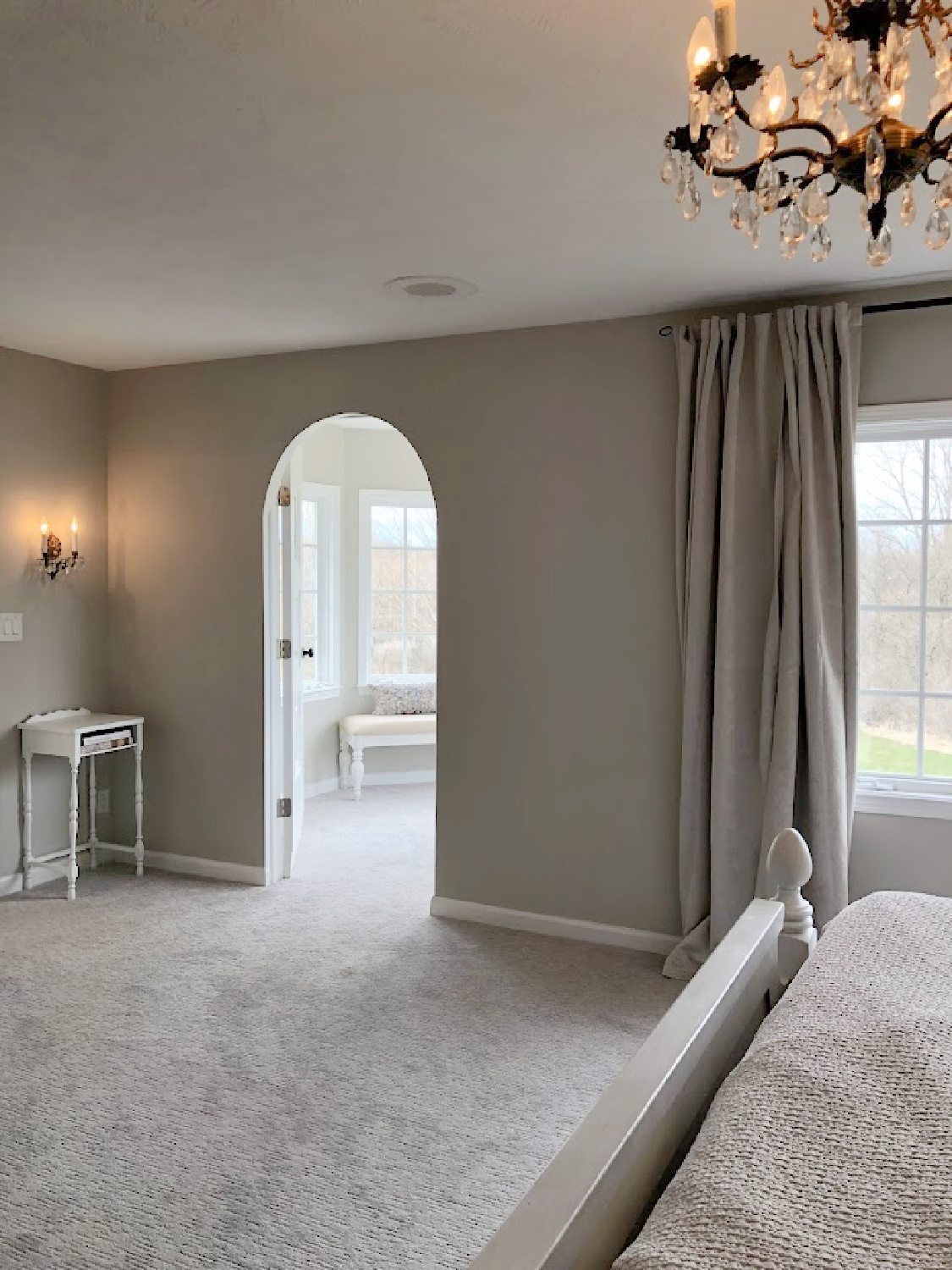 Arched doorway to turret designed sitting room in coastal bedroom remodel (SW Agreeable Gray on walls) at the Georgian - Hello Lovely Studio. #agreeablegray #swagreeablegray
