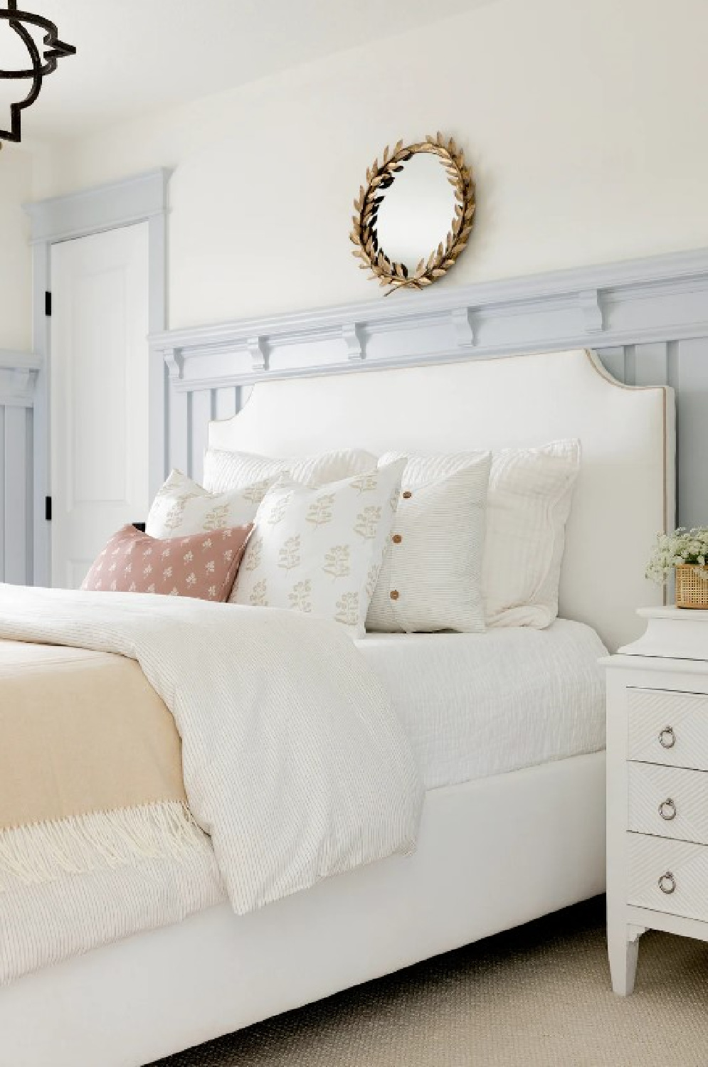 Bria Hammel designed bedroom with cool grey-blue wainscot, creamy walls, antique laurel round wreath mirror above bed, and bedding from BrookeandLou. 