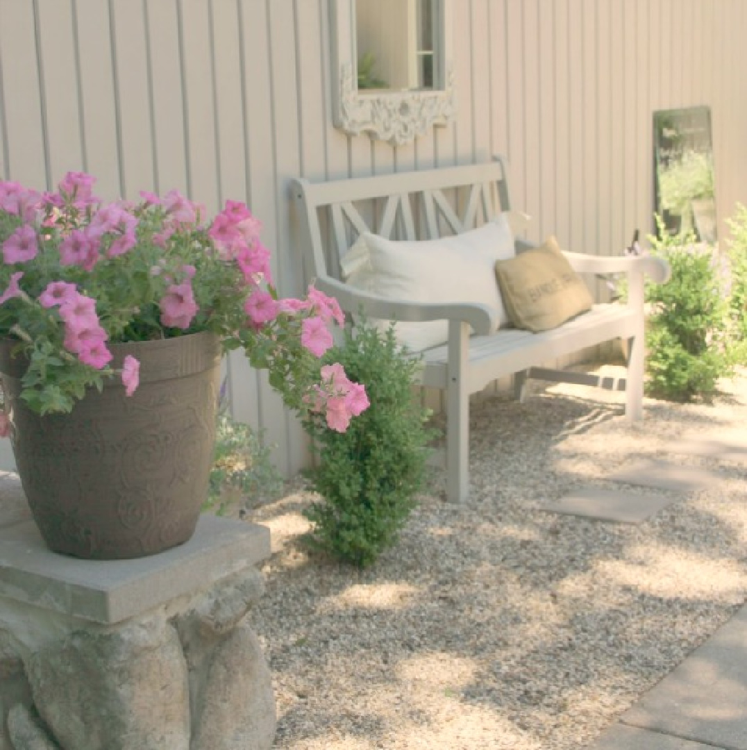 Pink petunias in a pot in our French country courtyard garden with pea gravel - Hello Lovely Studio.