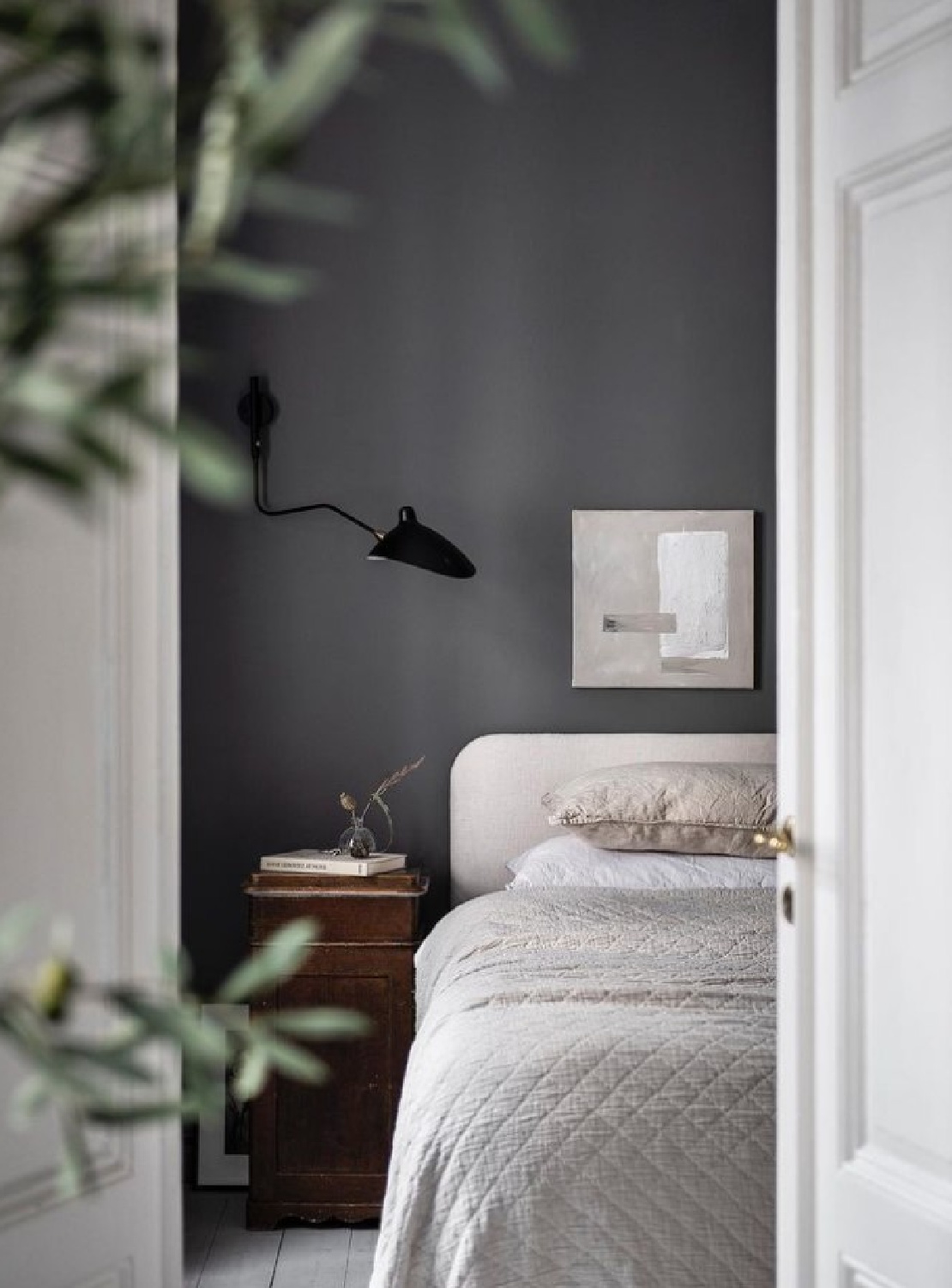 @elisabethphotography Stockholm apartment bedroom with a moody deep gray wall behind bed. #stockholmapartment #swedishhomes #chicbedrooms
