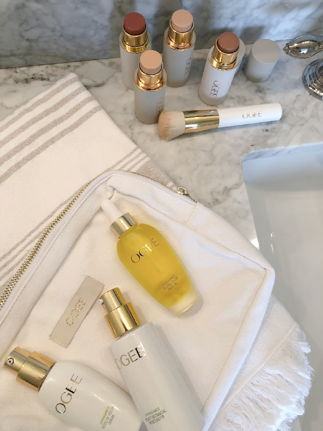 OGEE's organic skincare potions (Glow Trio), complexion sticks, face sticks, and blender brush on my vanity - Hello Lovely Studio. #organicmakeup #cleanmakeup #ogee
