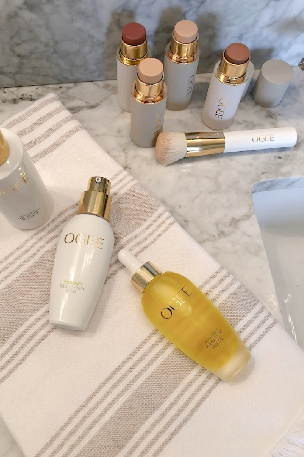 OGEE's organic glow trio potions, complexion sticks, face sticks, and blender brush on my vanity - Hello Lovely Studio. #organicmakeup #cleanmakeup #ogee
