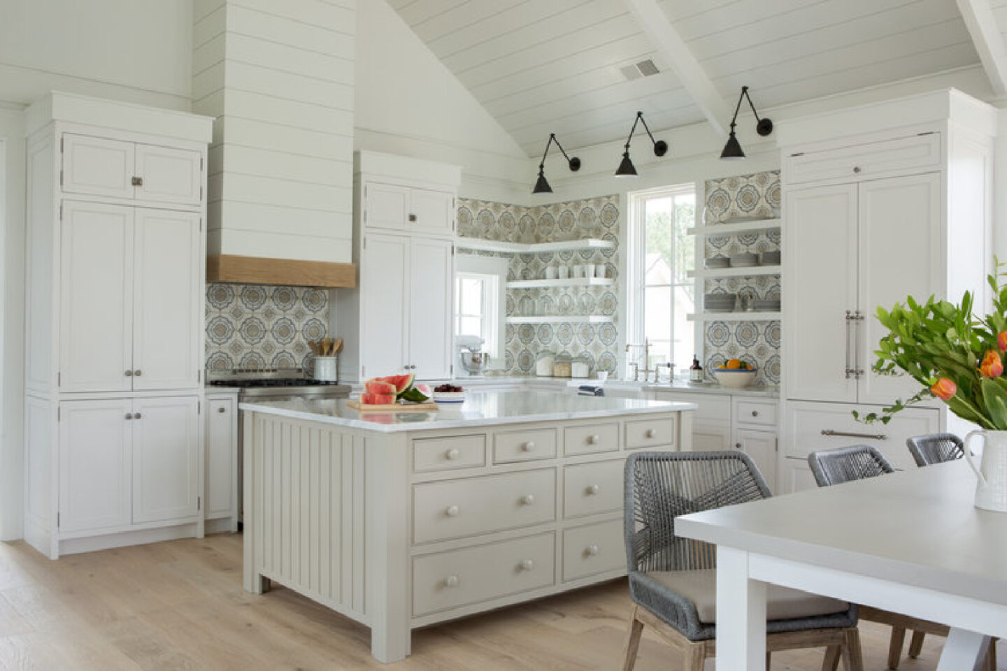 Benjamin Moore White OC-151 coastal kitchen with Shaker cabinets, backsplash (Duquesa Jasmine in Mezzanotte by Walker Zanger), and white oak floors. Lisa Furey Interiors.