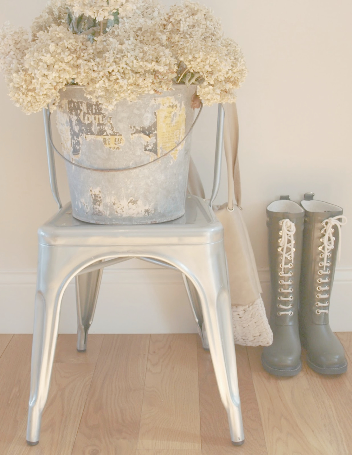 Hello Lovely's French farmhouse entry with Tolix chair, vintage bucket of hydrangea, handmade in France leather bag, and Ilse Jacobsen lace up boots. #frenchfarmhouse #hellolovelystudio