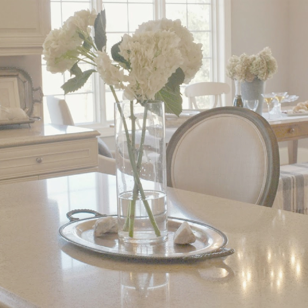 White Sand (Benjamin Moore) in my French country kitchen with Silestone Ivory Coast counters, warm white Thomasville cabinets, and white oak hardwood flooring - Hello Lovely Studio. #bmwhitesand #hellolovely #frenchkitchens