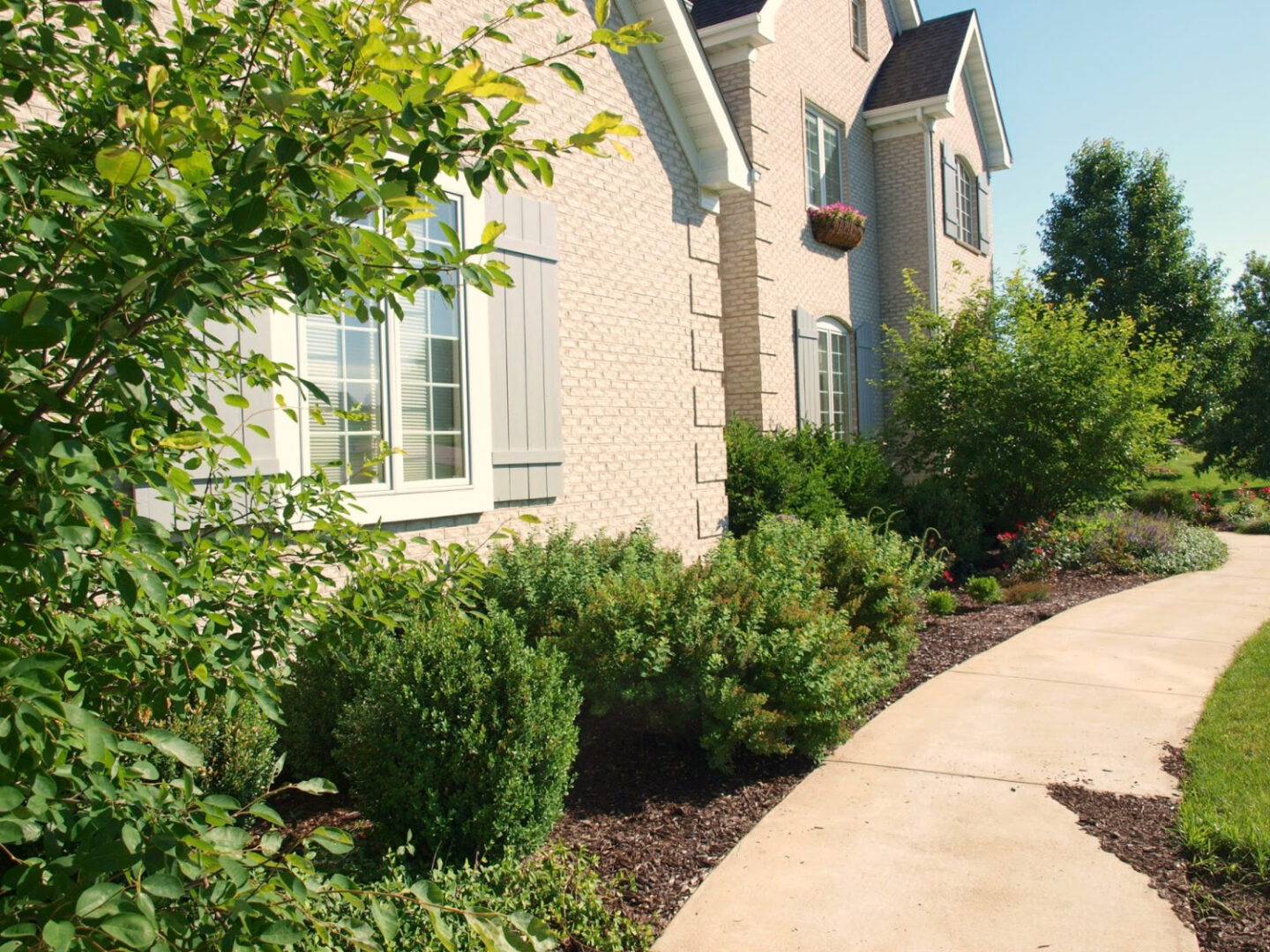 Hello Lovely designed this French country white brick with shutters French country manor house built in a country neighborhood. #hellolovely #frenchcountryexterior