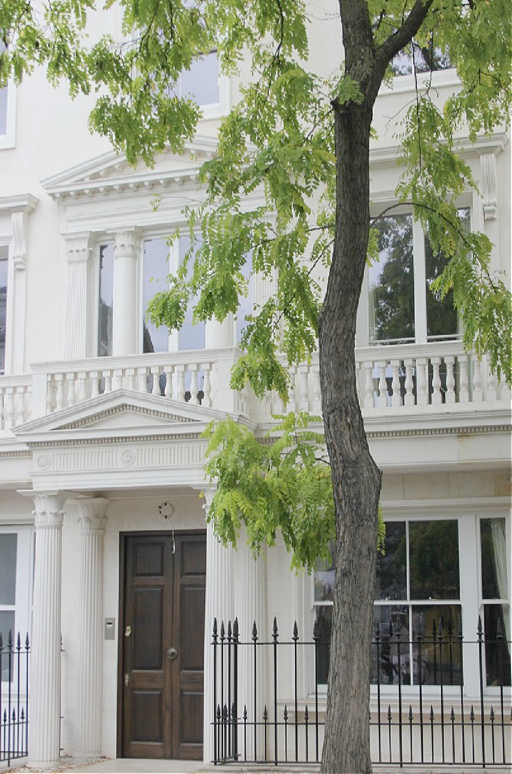 Beautiful sophisticated white row house exterior in Holland Park. Come explore paint colors for your front door. #frontdoorcolors #paintcolors #curbappeal