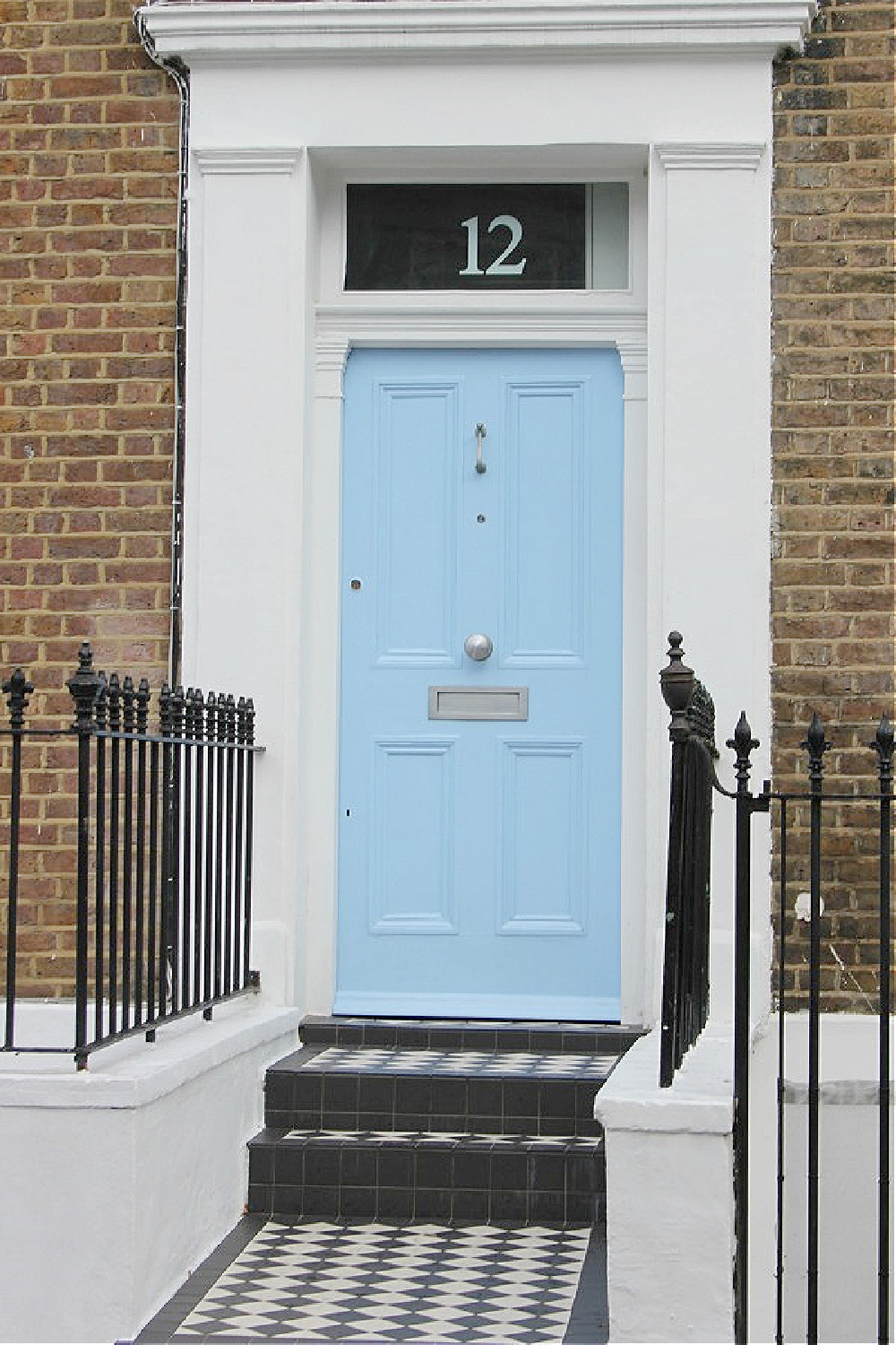 Beautiful sky blue bright front door and brick row house exterior in Notting Hill. Come explore paint colors for your front door. #frontdoorcolors #paintcolors #curbappeal