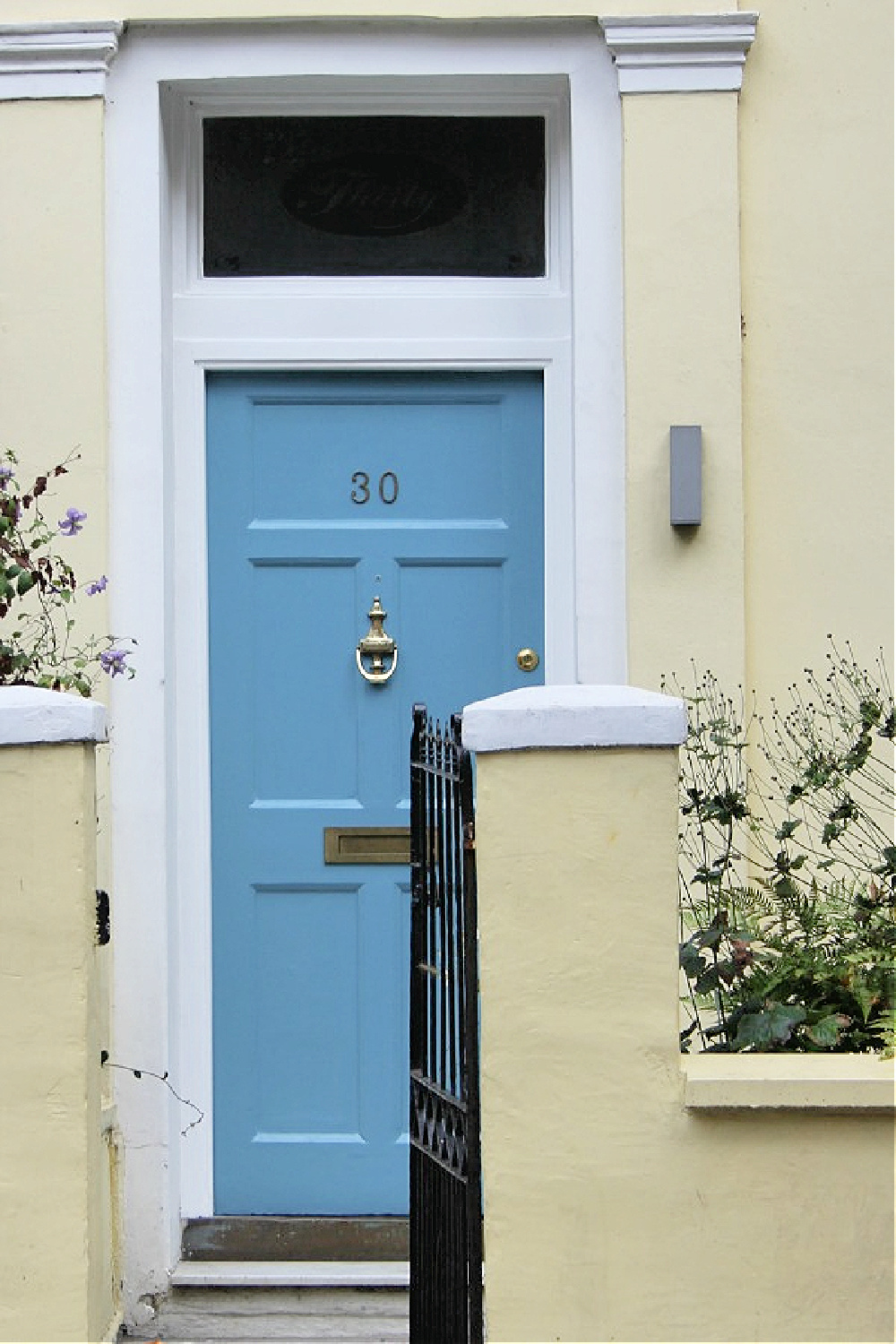 Swedish blue front door on yellow row house in Notting Hill. Come explore paint colors for your front door. #frontdoorcolors #paintcolors #curbappeal