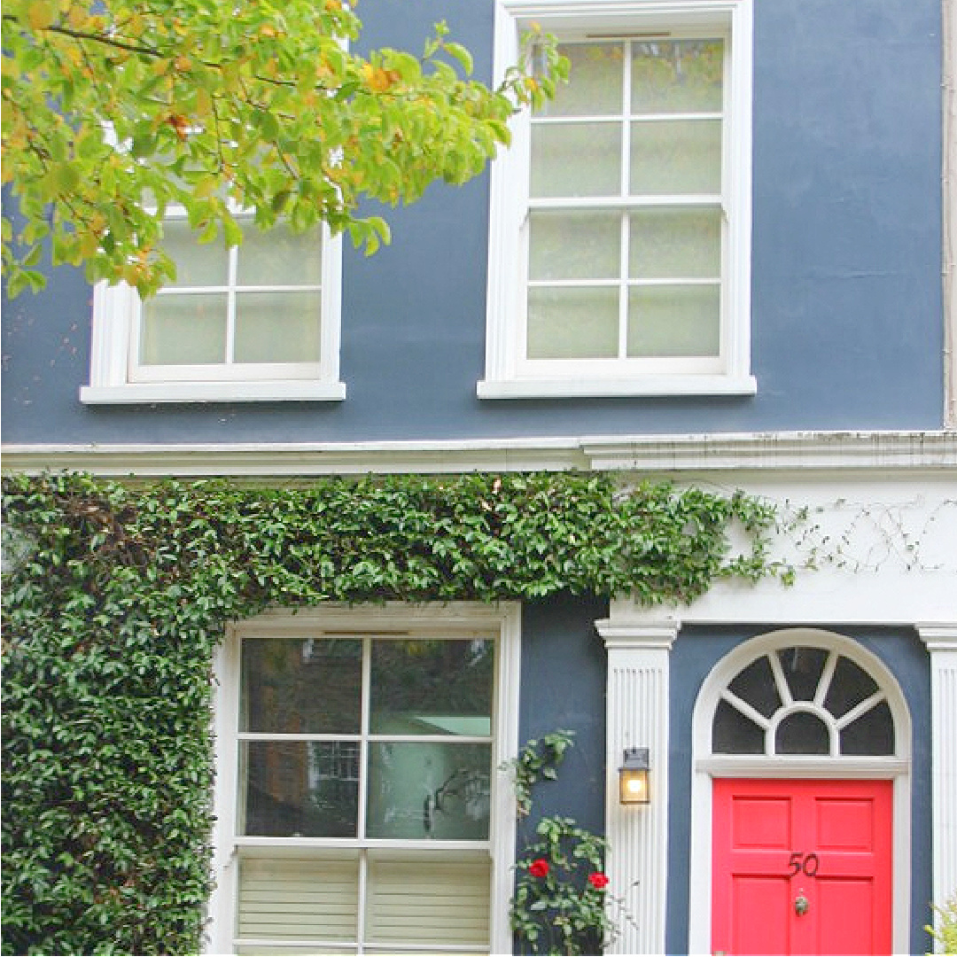 Bold red door on blue ivy covered house in Notting Hill. Come explore paint colors for your front door. #frontdoorcolors #paintcolors #curbappeal