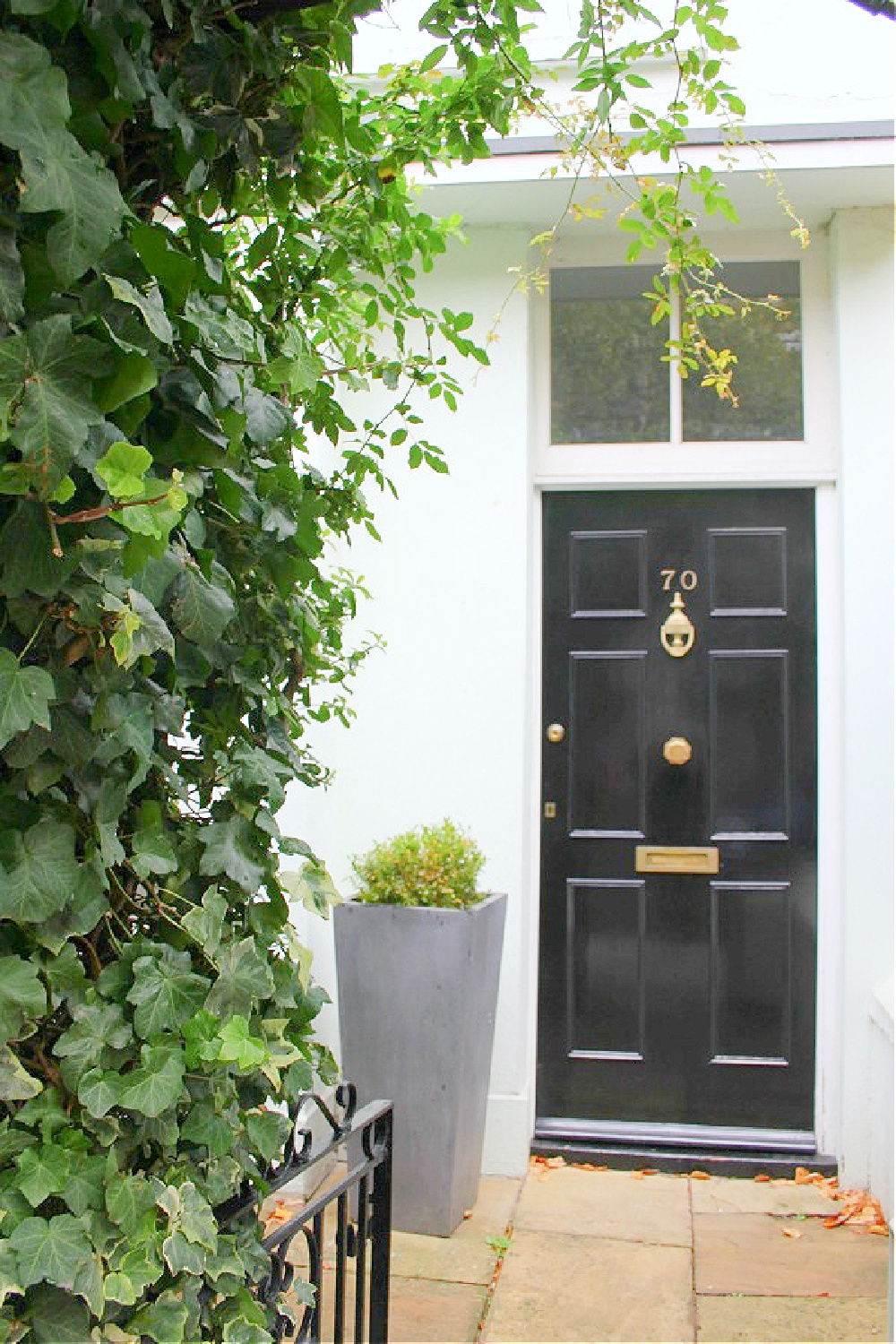 Beautiful and classic black door on white ow house in Notting Hill. Come explore paint colors for your front door. #frontdoorcolors #paintcolors #curbappeal