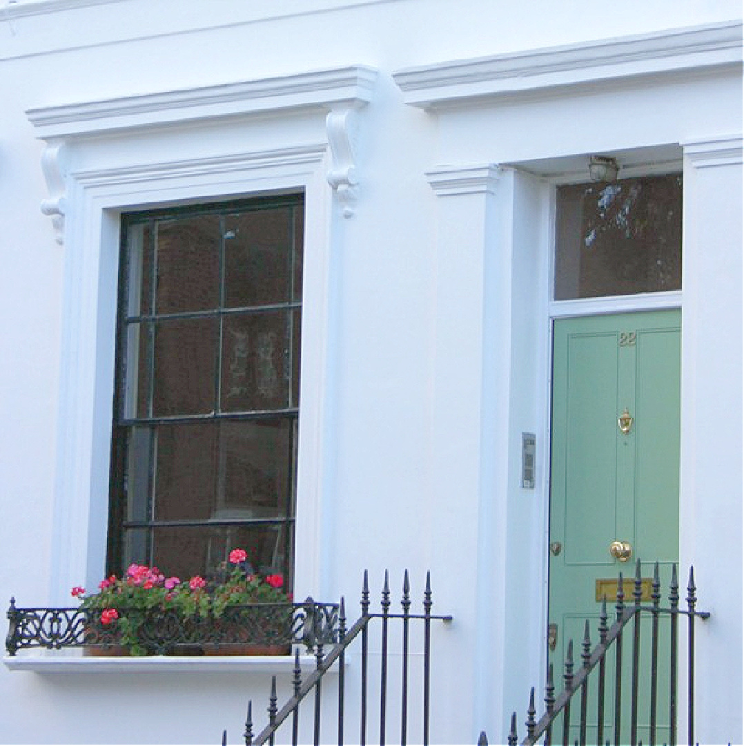 Gorgeous French green door with black trim on white row house in Notting Hill. Come explore paint colors for your front door. #frontdoorcolors #paintcolors #curbappeal