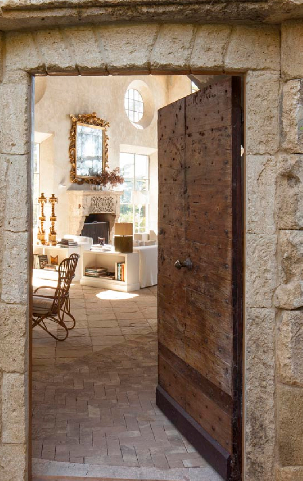 17th century antique walnut Italian door studded with nails at entrance of Richard Shapiro's Malibu beach house with Old World style.