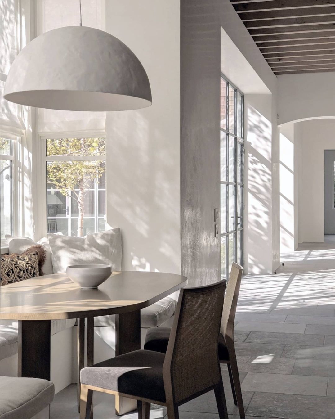 Breakfast nook with banquette and plaster pendant - interior design by Marie Flanigan in a Houston home designed by Kirby Mears.