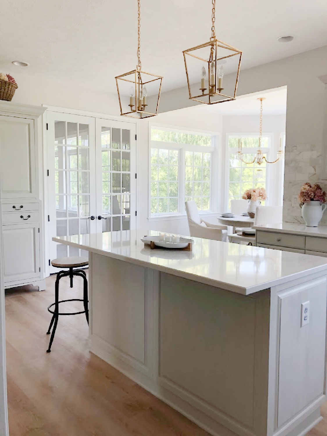 Modern French kitchen with Muse quartz (Viatera) and gilded iron Darlana pendants over island - Hello Lovely Studio. #modernfrench #greykitchens #viateramuse