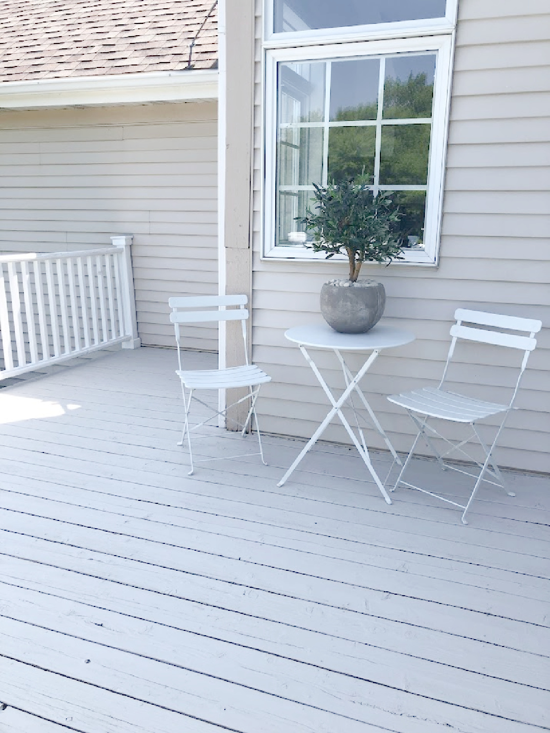 White bistro set on deck with stone/grey and white railing at the Georgian - Hello Lovely Studio.