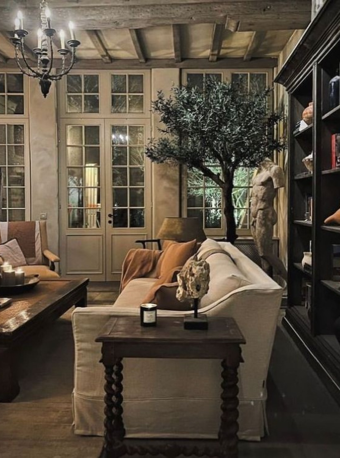 @thenotarybe - Belgian linen slope arm sofa and vuilt-in shelves in a cozy living orangery. #belgianinteriors