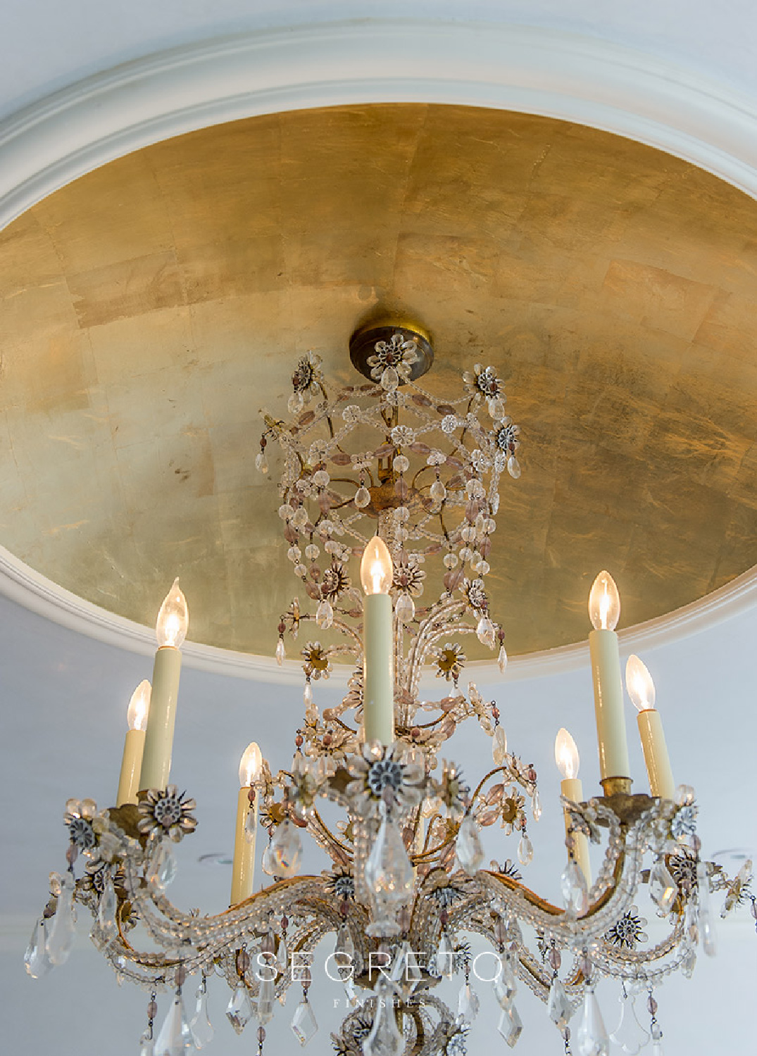 Gold leaf embellished ceiling medallion and beautiful chandelier - Segreto Finishes.