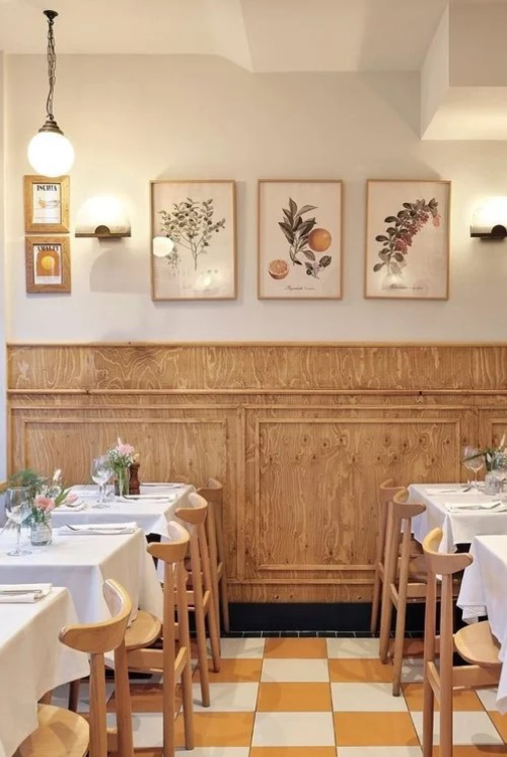 Ammonite (Farrow & Ball) on the upper walls of a charming restaurant with checkered floors in yellow and citrus prints. #farrowandballammonite