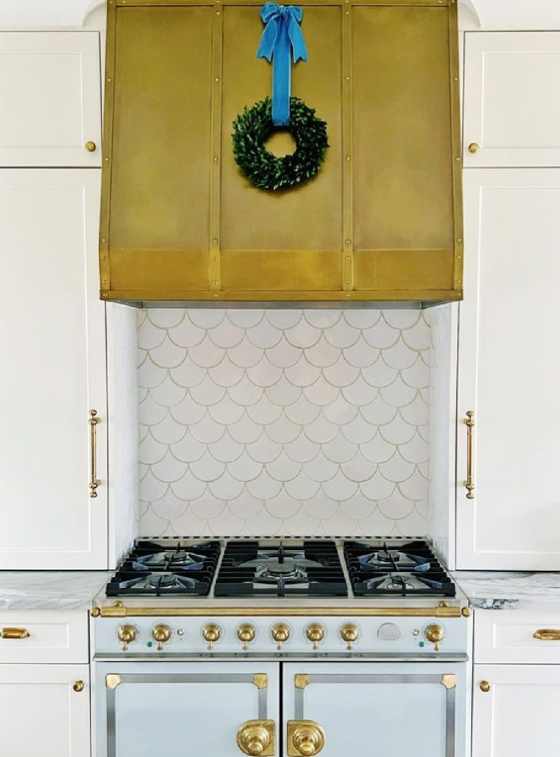 Brass range hood and La Cornue range in a timeless kitchen - M. E. Beck Design.