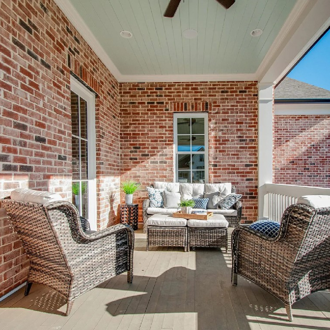 Beautiful haint blue ceiling on porch of a Franklin, TN red brick Charleston style house on Stephens Valley. #charlestonstyle #haintblueceiling #piazzas