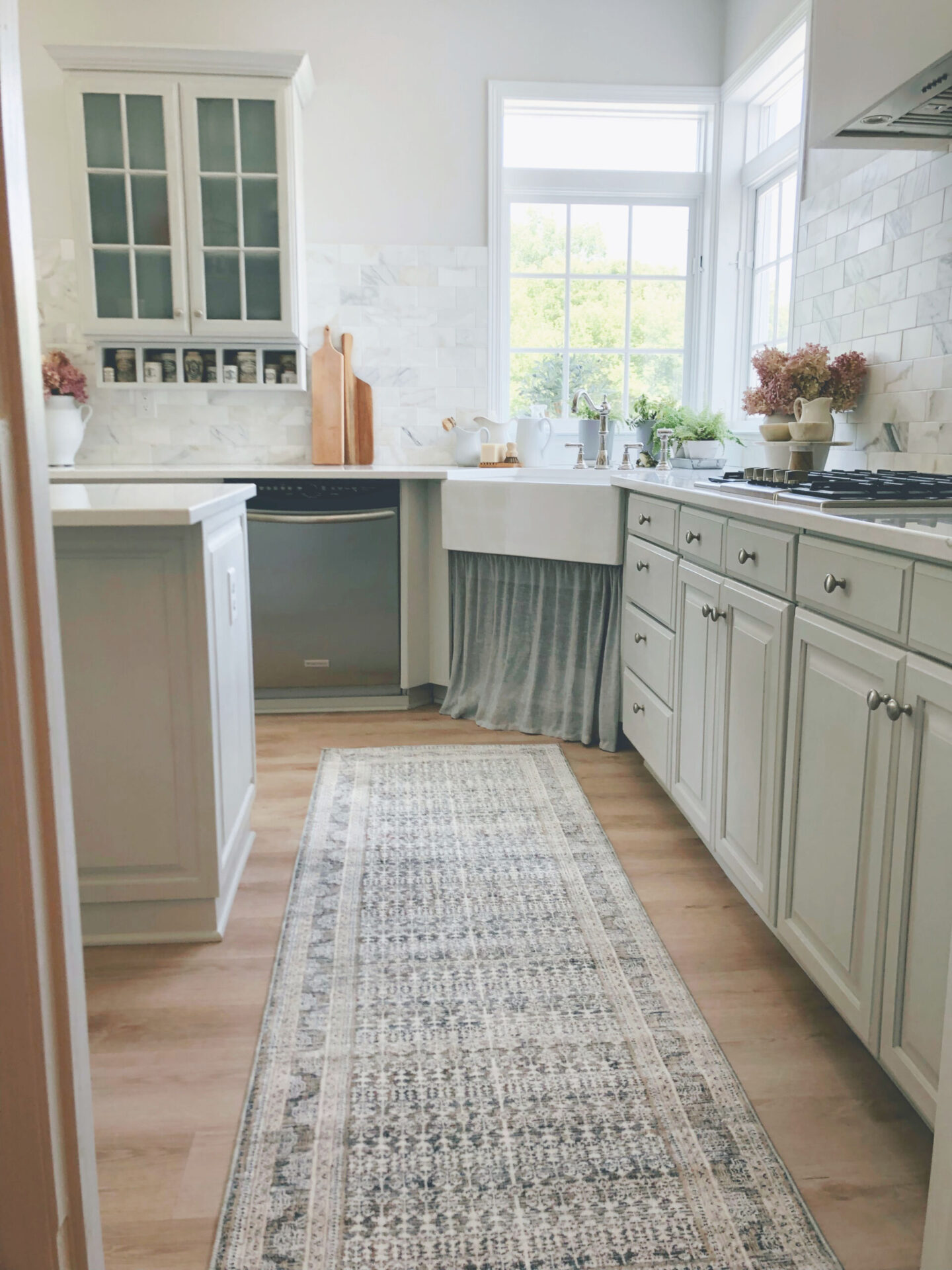 Hello Lovely's renovated Modern French kitchen with Amber Lewis/Loloi runner, F&B Pavilion Gray cabinets, and skirted farm sink.