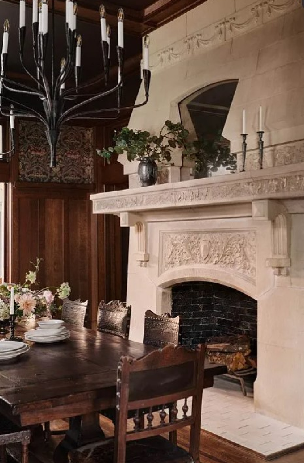 Dark wood paneled dining room with original French stone fireplace in Fixer Upper The Castle renovation.
