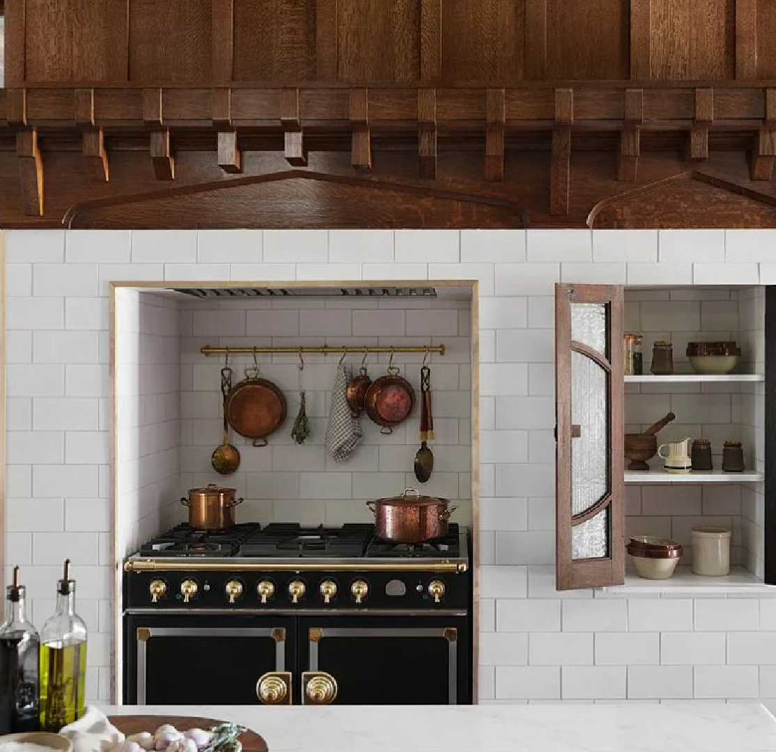 Beautiful French range tucked into niche with restored wood moldings above in Fixer Upper The Castle renovation.