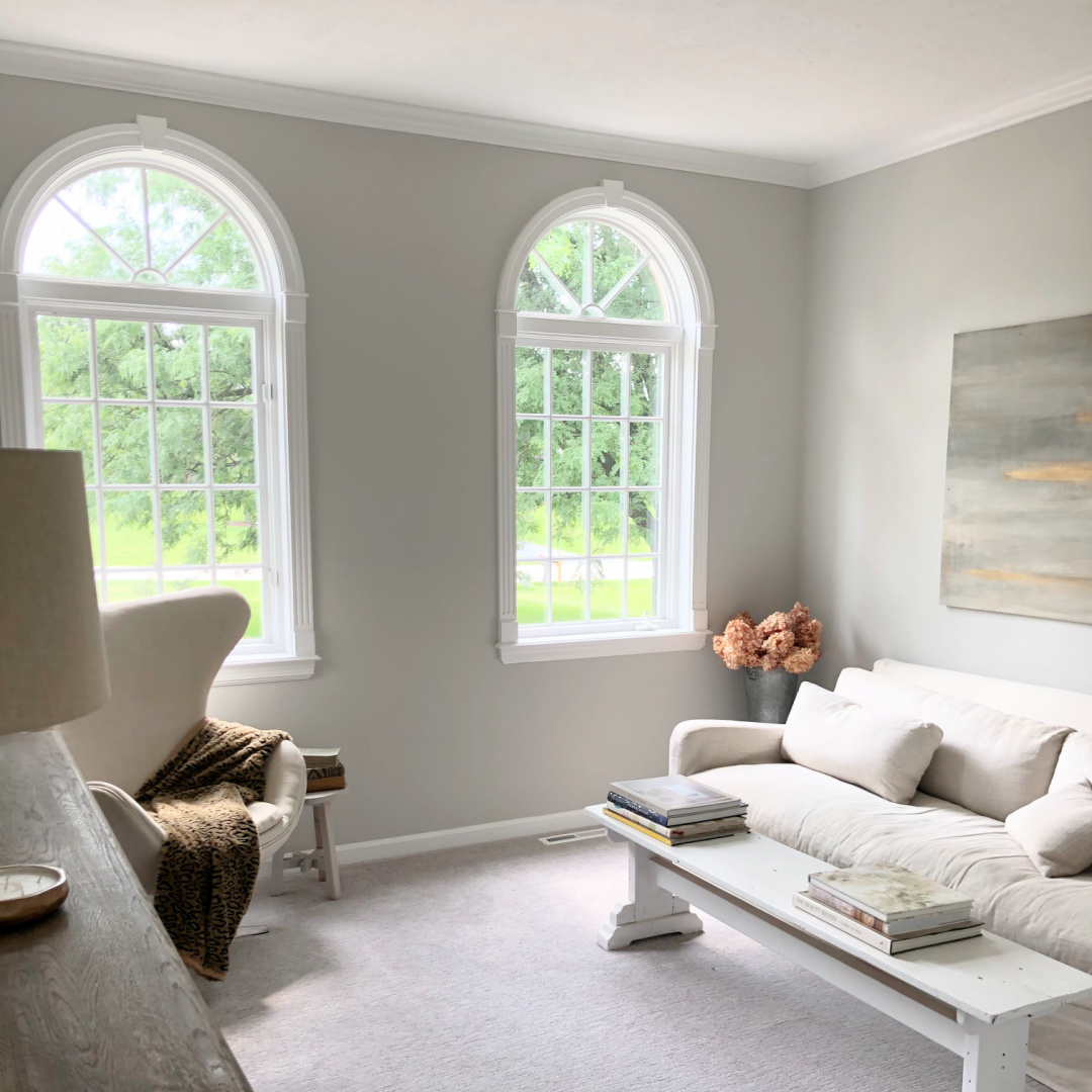 SW Repose Gray in living room with Belgian linen sofa, egg chair, and arched windows - Hello Lovely Studio. #reposegray #belgianstyle