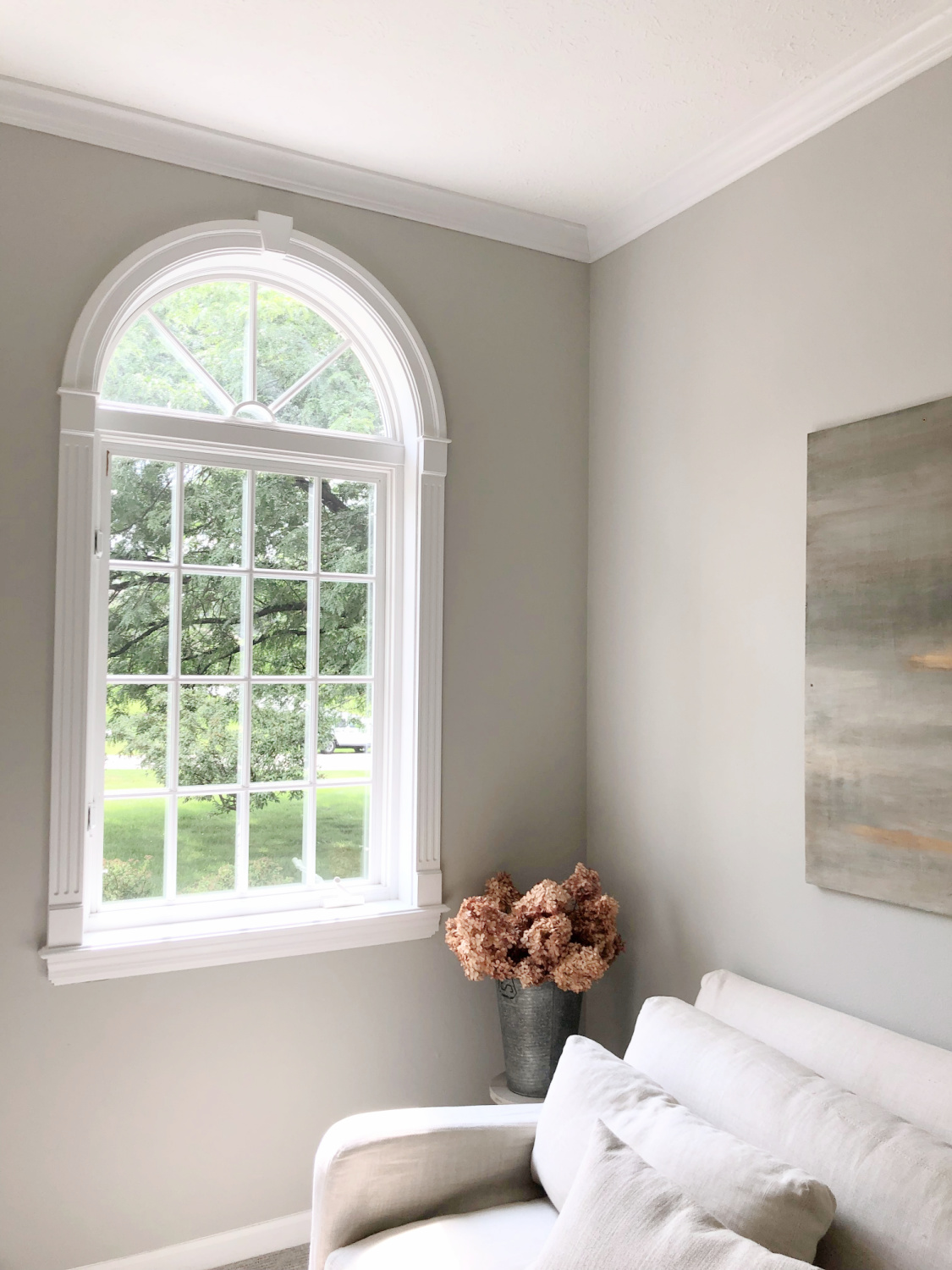 SW Repose Gray in living room with Belgian linen sofa, egg chair, and arched windows - Hello Lovely Studio. #reposegray #belgianstyle