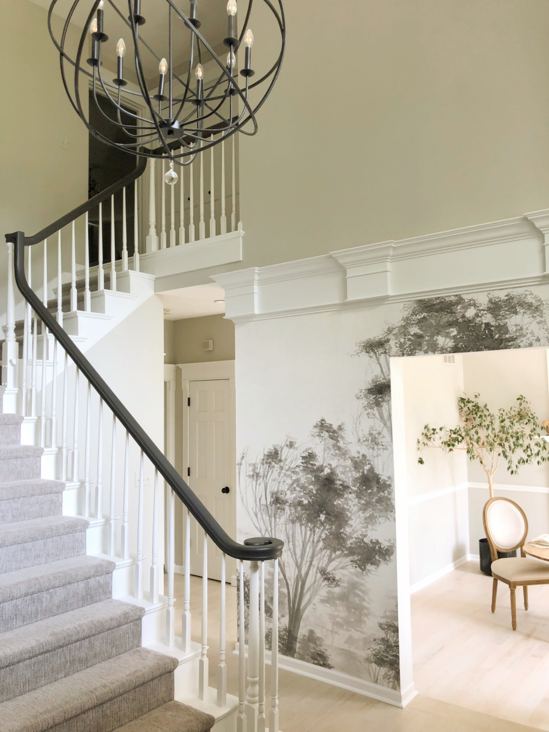 Sherwin-Williams Repose Gray in our two story entry with curving staircase and tree wallpaper - Hello Lovely Studio. #modernfrench #reposegray